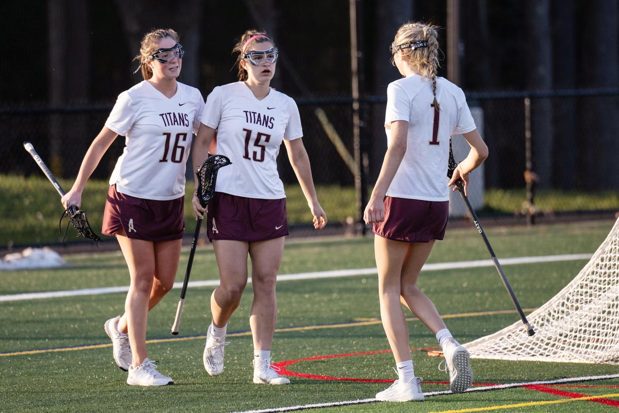Algonquin's Ella Nofsinger, left, and Grace Choita, right, congratulate Bella Roman after she scored against Shrewsbury during a girls' lacrosse game Tuesday in Northborough.