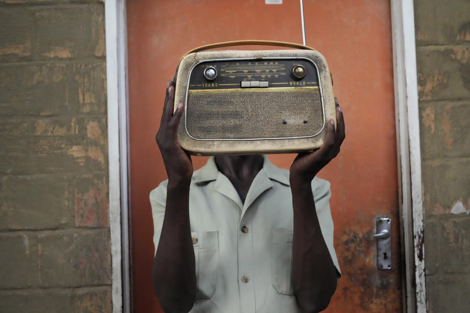 Ngwiza Khumbulani Moyo, a vintage collector holds an old radio set outside his home in Bulawayo, Wednesday, Feb. 15, 2023. According to a survey by Afrobarometer, radio is “overwhelmingly” the most common source of news in Africa. About 68% of respondents said they tune in at least a few times a week, compared to about 40% who said they use social media and the internet. (AP Photo/Tsvangirayi Mukwazhi)