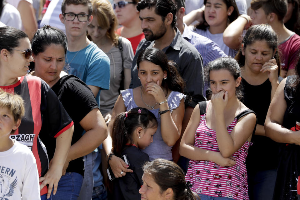 Neighbors of Argentine soccer player Emiliano Sala, wait for his remains to depart for Santa Fe after his wake in Progreso, Argentina, Saturday, Feb. 16, 2019. The Argentina-born forward died in an airplane crash in the English Channel last month when flying from Nantes in France to start his new career with English Premier League club Cardiff. (AP Photo/Natacha Pisarenko)