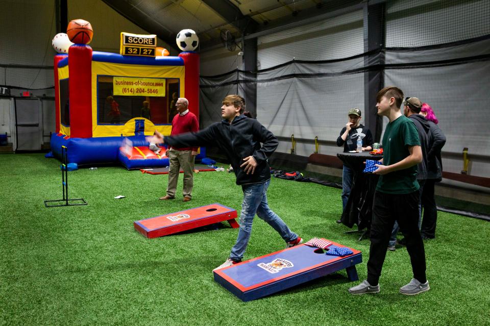 Landon Knoch (black shirt), 14 of Lancaster, plays a game of corn hole with Coleson Ross, 14, of Lancaster, during the open house at Beavers Dam Sports Complex in Lancaster, Ohio on December 3, 2021.