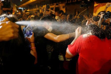 Protesters are pepper sprayed by police during a protest against what they call Beijing's interference over local politics and the rule of law, a day before China's parliament is expected to announce their interpretation of the Basic Law in light of two pro-independence lawmakers' oath-taking controversy in Hong Kong, China, November 6, 2016. REUTERS/Tyrone Siu