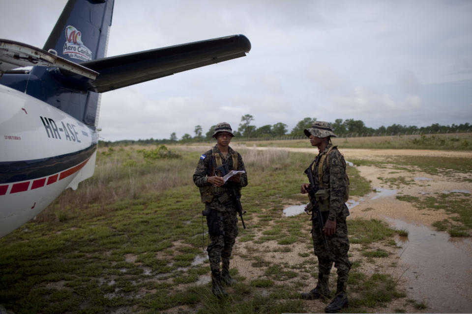 Honduran soldiers stand next to a plane after checking passengers information in Brus Laguna , Honduras, Monday, May 21, 2012. On Friday May 11, a joint Honduran-U.S. drug raid, on a helicopter mission with advisers from the DEA, appears to have mistakenly targeted civilians in the remote jungle area, killing four riverboat passengers and injuring four others. Later, according to villagers, Honduran police narcotics forces and men speaking English spent hours searching the small nearby town of Ahuas for a suspected drug trafficker.(AP Photo/Rodrigo Abd)