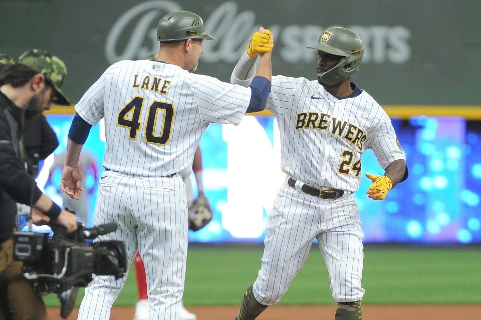 Andrew McCutchen celebrates his home run Friday with third base coach Jason Lane  in the first inning at American Family Field.