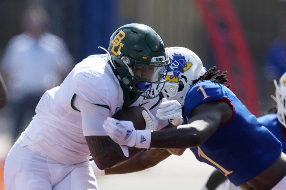 Baylor running back Trestan Ebner, left, is tackled by Kansas safety Kenny Logan Jr. (1) during the first half of an NCAA college football game in Lawrence, Kan., Saturday, Sept. 18 2021. (AP Photo/Orlin Wagner)