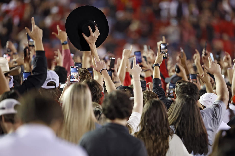 Texas Tech fans sing the school song on the field after an NCAA college football game against Iowa State, Saturday, Nov. 13, 2021, in Lubbock, Texas. (AP Photo/Brad Tollefson)