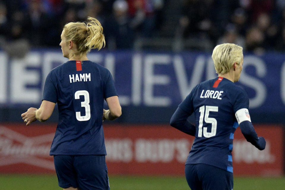 United States midfielder Samantha Mewis (3) and forward Megan Rapinoe (15) play against England during the second half of a SheBelieves Cup women's soccer match Saturday, March 2, 2019, in Nashville, Tenn. Mewis honors Mia Hamm and Rapine honors Audre Lorde by wearing their names on the back of their jerseys. (AP Photo/Mark Zaleski)