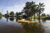 Martin Almanza paddles a canoe through some street flooding following landfall of Hurricane Laura on Thursday, Aug. 27, 2020 in Galveston, Texas. (Brett Coomer/Houston Chronicle via AP)