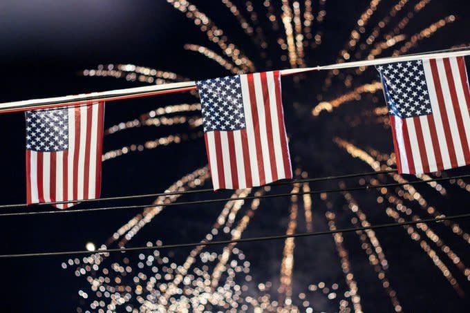 low angle of american flag fourth of july decorations with fireworks bursting in the background