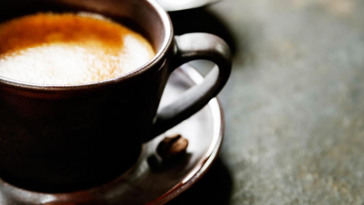 Coffee in a dark mug and saucer