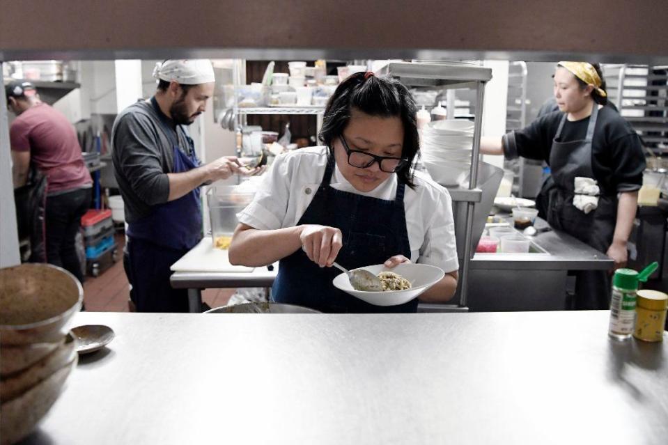 Chef Minh Phan plating a dish at Porridge + Puffs in Historic Filipinotown.