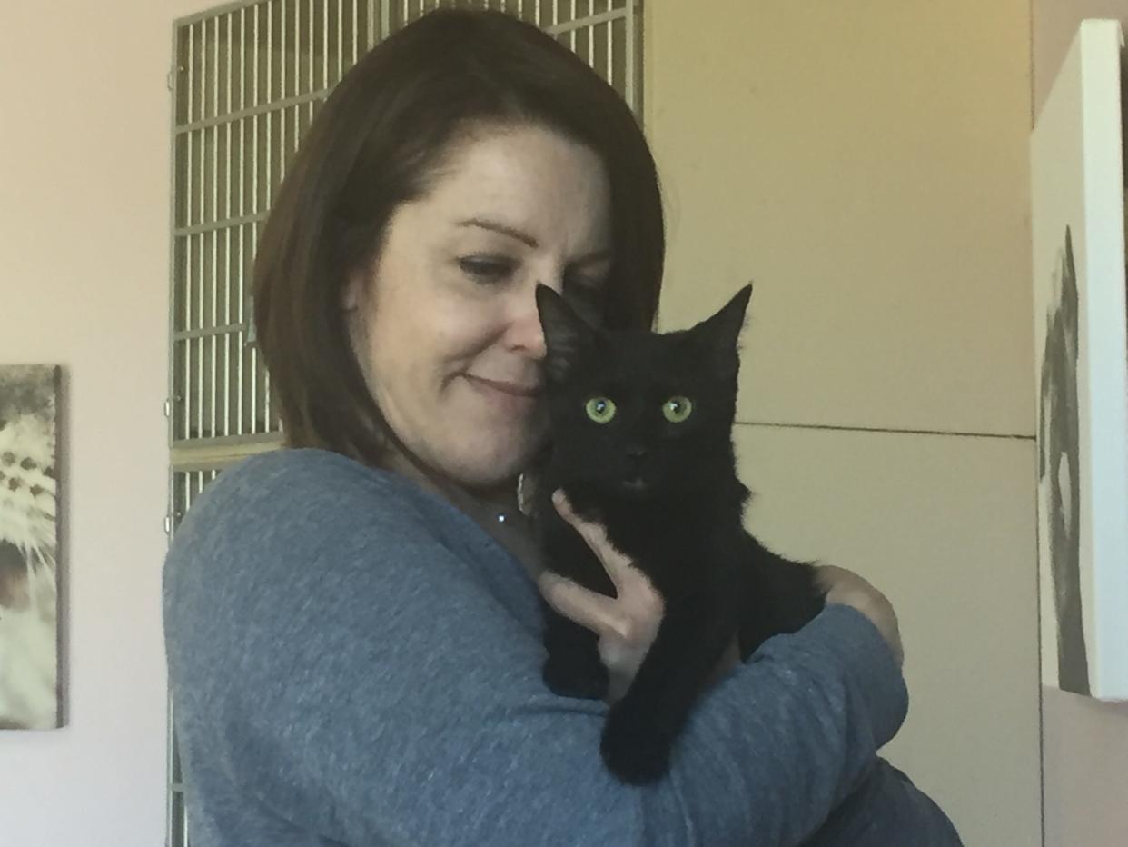 Linda Chambers, director of the Humane Society of Richland County, cradles Dink, one of several black cats available for adoption. He wound up in the shelter when his owner was placed in hospice care.