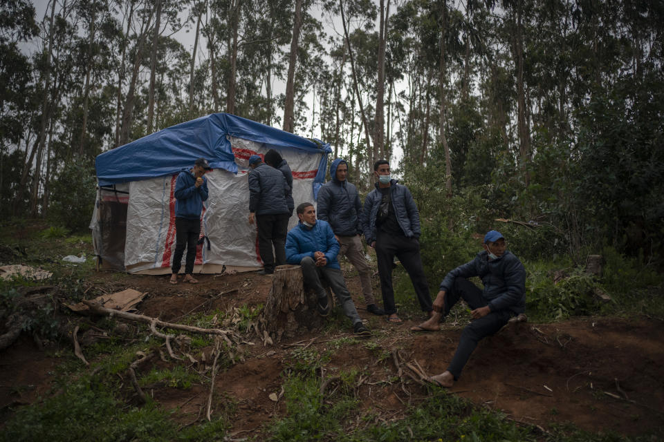 Migrants rest in Las Raices camp in San Cristobal de la Laguna, in the Canary Island of Tenerife, Spain, Thursday, March 18, 2021. Several thousand migrants have arrived on the Spanish archipelago in the first months of 2021. Due to the terrible living conditions and the poor quality of food and water at the Las Raices camp, some migrants have decided to leave the camp and sleep in shacks in a nearby forest instead. (AP Photo/Joan Mateu)