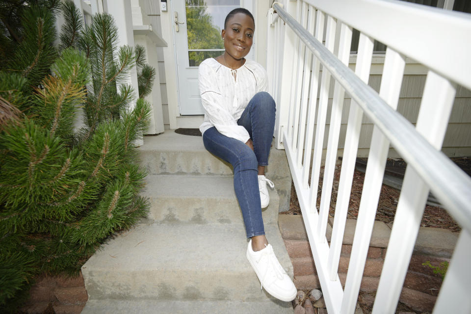 Fashion blogger Abena Antwiwaa poses at her home in Aurora, Colo., on Friday, Aug. 6, 2021. Antwiwaa is one of dozens of influencers, ranging from busy moms and fashion bloggers to African refugee advocates and religious leaders, getting paid by the state to post vaccine information on a local level in hopes of stunting a troubling summer surge of COVID-19. (AP Photo/David Zalubowski)
