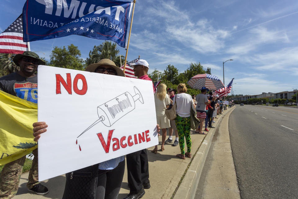 A protester holds an anti-vaccination sign as supporters of President Donald Trump rally to reopen California as the coronavirus pandemic continues to worsen in May in Woodland Hills, Calif. (David McNew/Getty Images)
