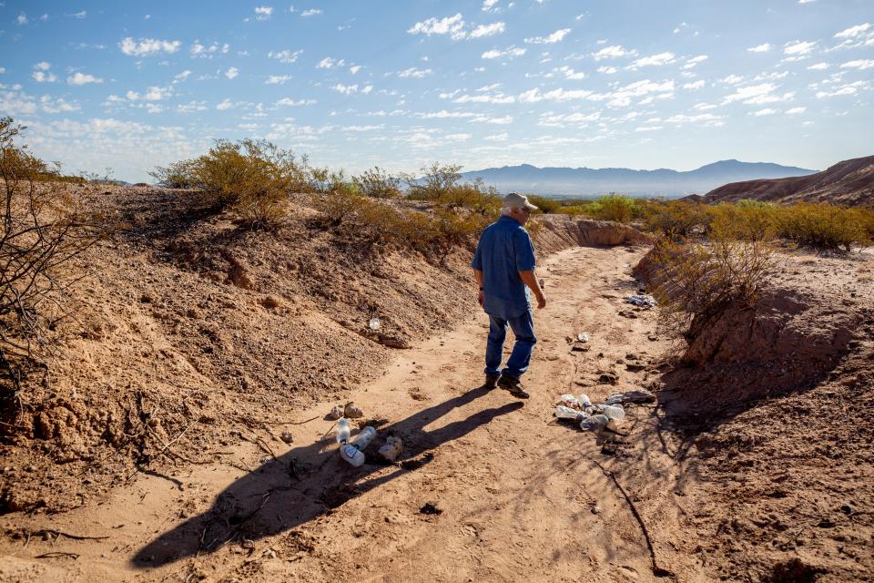 Randy Eiland camina más allá de las botellas de agua dejadas por migrantes que cruzaron cerca de su casa durante su caminata matutina. Randy Eiland y su esposa Carol encontraron un migrante muerto a apenas unos cientos de metros de su casa rural en Nuevo México en 2023.