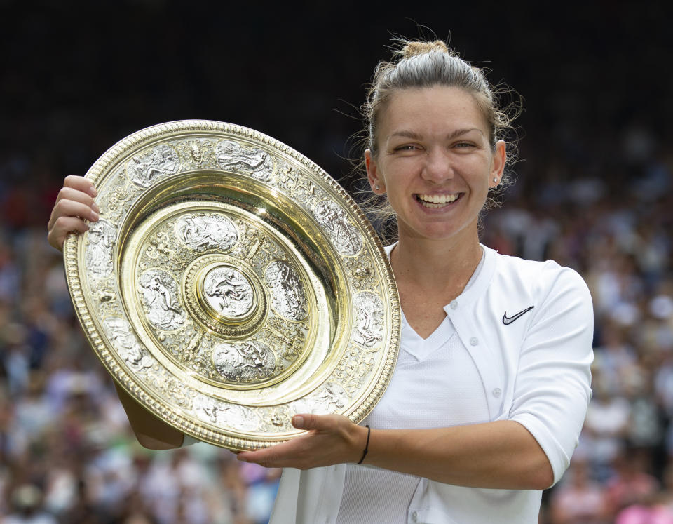 Simona Halep of Romania holds the trophy aloft after her victory over Serena Williams of USA in the Final of the Ladies Singles on Day Twelve of The Championships (Photo by Visionhaus/Getty Images)