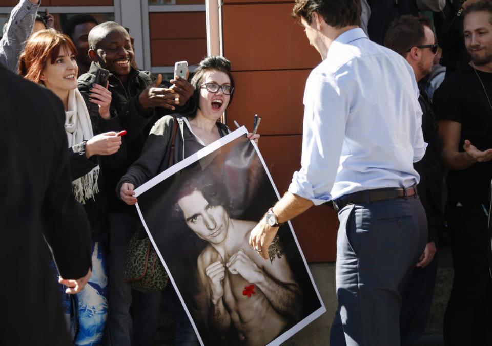 Prime Minister Justin Trudeau looks at a portrait of himself held by Kelly Archibald as he meets with students at the Southern Alberta Institute of Technology in Calgary, Alta., Tuesday, March 29, 2016. THE CANADIAN PRESS/Jeff McIntosh