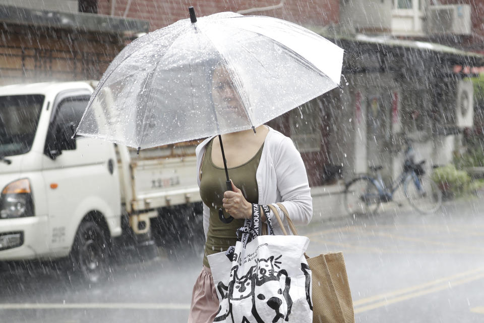 A woman holds an umbrella in heavy rain after Typhoon Saola moves away in Taipei, Taiwan, Thursday, Aug. 31, 2023. (AP Photo/Chiang Ying-ying)