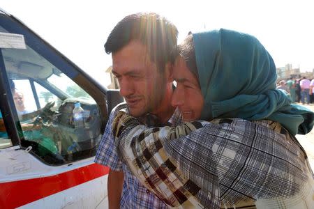 Abdullah Kurdi mourns with his relative during the funeral of his toddlers, who drowned with their mother as they were trying to reach Greece, at the Syrian border town of Kobani September 4, 2015. Two Syrian toddlers, including three-year-old Aylan Kurdi, who drowned with their mother as they were trying to reach Greece were laid to rest in the Syrian town of Kobani on Friday, a Reuters witness said. Abdullah Kurdi, their father, wept as their bodies were buried alongside each other in the "Martyrs' Ceremony" in the predominantly Kurdish town of Kobani, also known as Ayn al-Arab, near the border with Turkey. REUTERS/Rodi Said