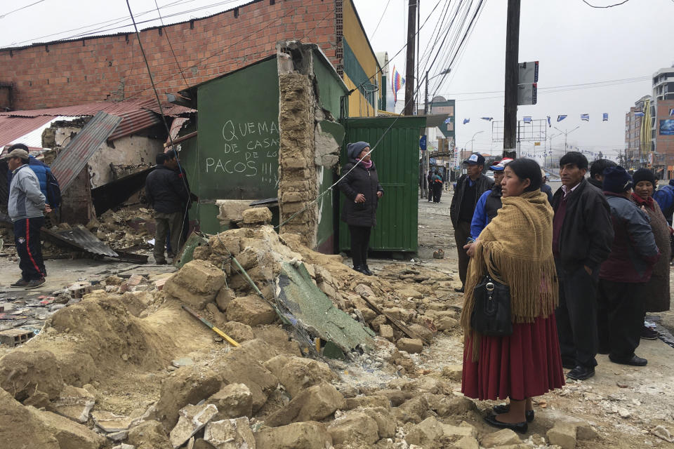 People gather outside a police station attacked by supporters of former President Evo Morales in El Alto, outskirts of La Paz, Bolivia, Tuesday, Nov. 12, 2019. Bolivia faced political vacuum Tuesday, while Morales fled the country on a Mexican plane following weeks of widespread protests fed by allegations of electoral fraud in the Oct. 20 presidential election that he claimed to have won (AP Photo/Natacha Pisarenko)