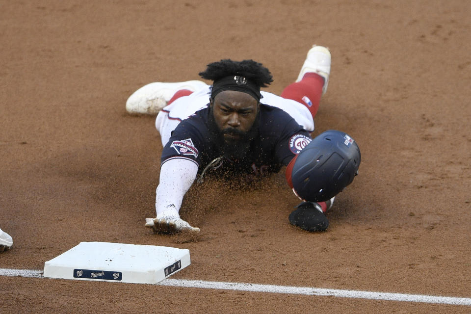 Washington Nationals' Josh Harrison slides into third base on a single by Eric Thames during the second inning of a baseball game against the Tampa Bay Rays, Monday, Sept. 7, 2020, in Washington. (AP Photo/Nick Wass)