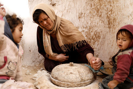 Saliha Mohamedi, 36, grinds wheat at her troglodyte house on the outskirts of Matmata, Tunisia, February 5, 2018. "I don't want to leave my house, it would be as if I was throwing my life and my traditions away," Saliha said. REUTERS/Zohra Bensemra