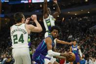 Charlotte Hornets' Jalen McDaniels looks to pass around Milwaukee Bucks' Jrue Holiday and Pat Connaughton during the first half of an NBA basketball game Wednesday, Dec. 1, 2021, in Milwaukee. (AP Photo/Morry Gash)