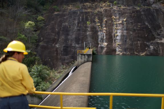 A worker stands near a dam at a hydroelectric plant run by the Costa Rican Electricity Institute in Guanacaste, Costa Rica.