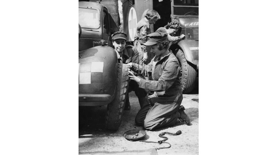 Princess Elizabeth changing the tire of a vehicle as she trains at as ATS Officer during World War Two, at the ATS training centre in 1945