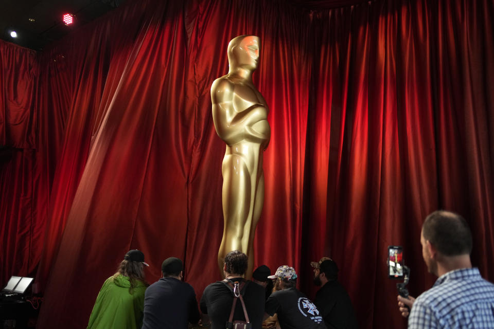 Workers move an Oscar statue during preparations for Sunday's 95th Academy Awards, Saturday, March 11, 2023, in Los Angeles. (AP Photo/John Locher)