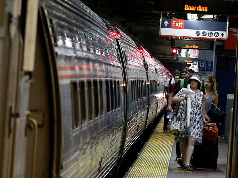 FILE PHOTO: Passengers board an Amtrak train inside New York's Penn Station, the nation's busiest train hub, which will be closing tracks for repairs causing massive disruptions to commuters in New York City