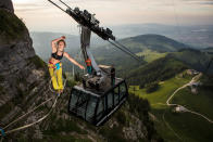 <p>Lenoble, 25, walks a slackline between two cable cars on the mountain of Moléson in Switzerland. (Photo: Martin Knobel/Caters News) </p>