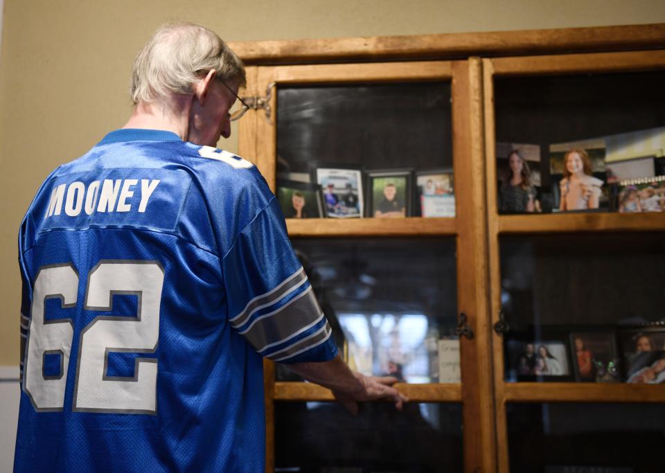 Former Texas Tech and Detroit Lions linebacker Ed Mooney looks at photos of his children and grandchildren this past week at his home in Lubbock. Mooney played for Detroit from 1968-72, and the Lions play the San Francisco 49ers on Sunday in the NFC championship game.