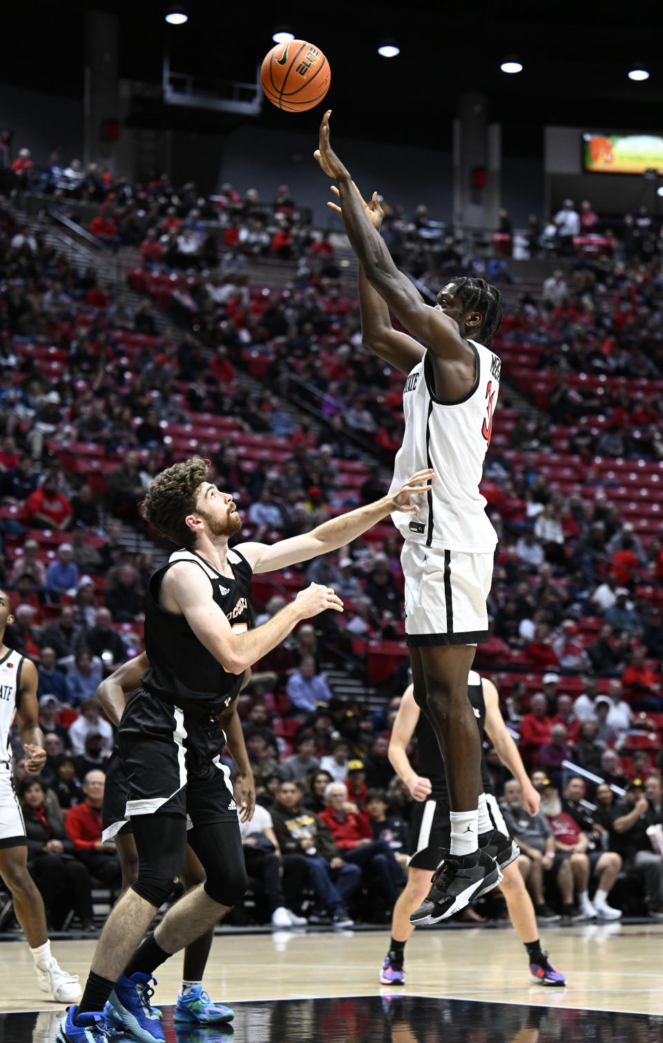 San Diego State forward Nathan Mensah (31) shoots over Occidental forward Bernard Cassidy during the first half of an NCAA college basketball game Friday, Dec. 2, 2022, in San Diego. (AP Photo/Denis Poroy)