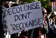 FILE PHOTO - An Aboriginal protester holds a placard as she stands outside the Australian Prime Minister's office in Sydney, Australia, July 6, 2015. REUTERS/David Gray/File photo