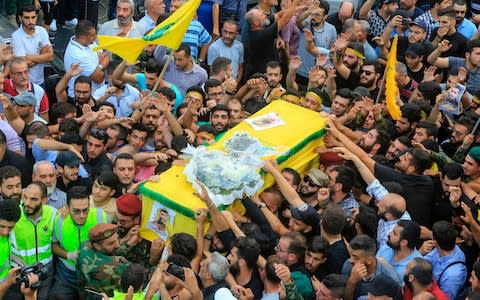 Members of Lebanon's Shia Hizbollah movement carry the coffin of a fighter killed in Israeli strikes in Syria, during the funeral in the Ghobeiry neighbourhood of southern Beirut - Credit: AFP