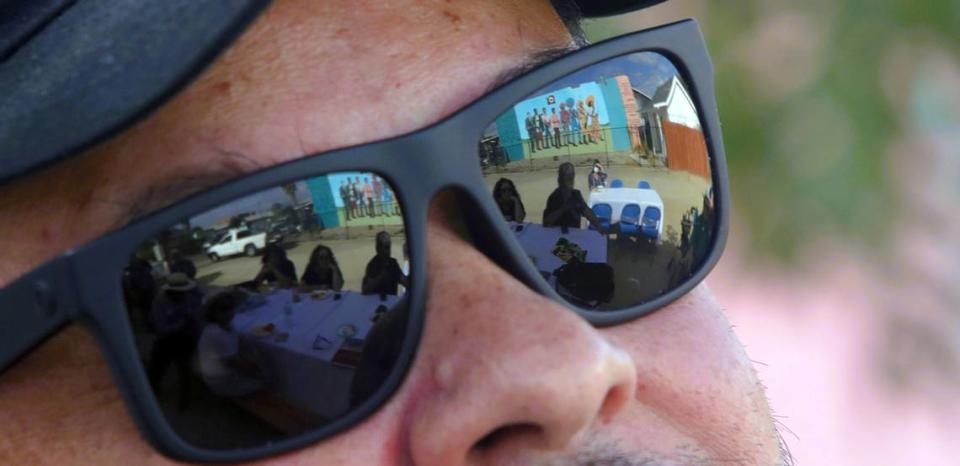 The resurrected 1968 mural drawn by Antonio Bernal is reflected on the sunglasses of the artist’s son, Hugo Hopping, at Oct. 22, 2023 memorial.