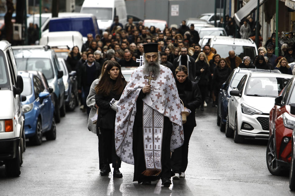 An Orthodox priest leads the funeral procession of 23-year old Ifigenia Mitska, at Giannitsa town, northern Greece, Saturday, March 4, 2023. Over 50 people — including several university students — died when a passenger train slammed into a freight carrier just before midnight Tuesday. The government has blamed human error and a railway official faces manslaughter charges. (AP Photo/Giannis Papanikos)