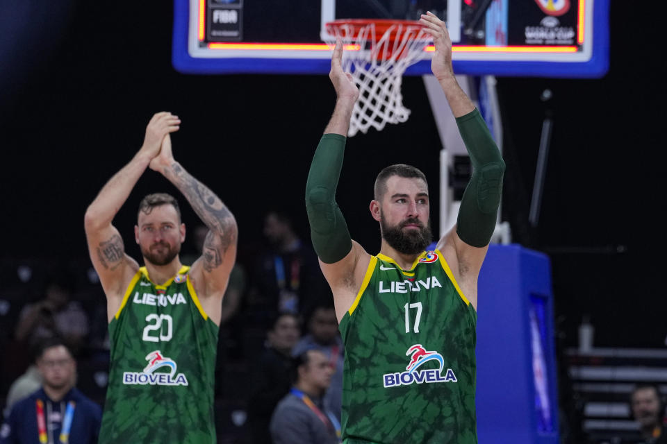 Lithuania's Jonas Valanciunas (17) and Donatas Motiejunas (20) thank their fans following a win over the United States in a Basketball World Cup second-round match in Manila, Philippines Sunday, Sept. 3, 2023.(AP Photo/Michael Conroy)