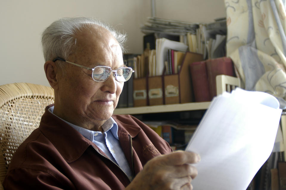 In this Oct. 2004, photo and released by Li Nanyang, Communist Party veteran Li Rui reads in his study in Beijing. Li Nanyang, daughter of Li Rui, boycotted her father's funeral Wednesday, Feb. 20, 2019, calling it an improper tribute to a man who once worked for Mao Zedong but later became a fierce critic of the regime. (Li Nanyang via AP)