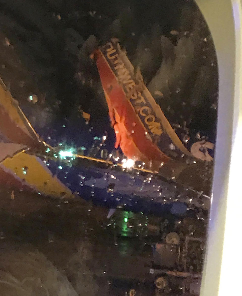 This photo taken onboard by a passenger on a Southwest Airlines flight to Atlanta appears to show the top fin of another Southwest Airlines plane clipped off after the two planes collided, Saturday, July 20, 2019, on the tarmac of Nashville International Airport, in Nashville, Tenn. The airline says both planes returned to the gate "under their own power" and were taken out of service for evaluation. The Southwest flights will continue to the scheduled destinations using news planes. (Eric Borden via AP)