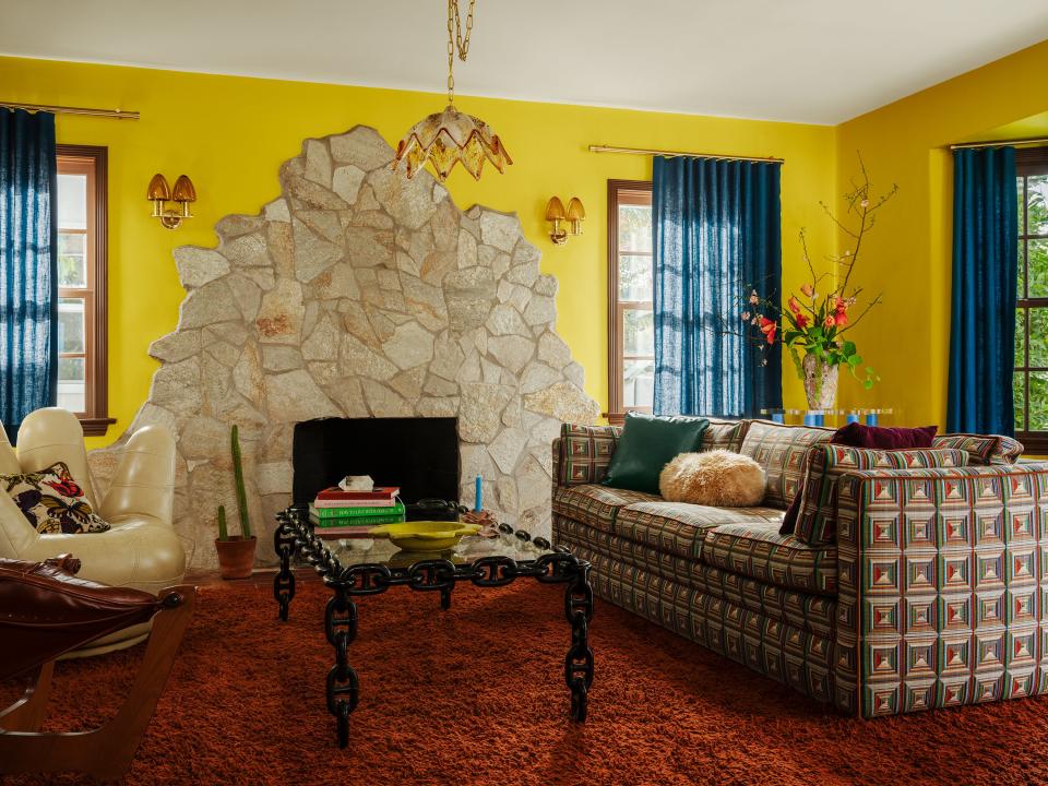 The massive flagstone fireplace sets the tone for the ’70s-inspired living room.