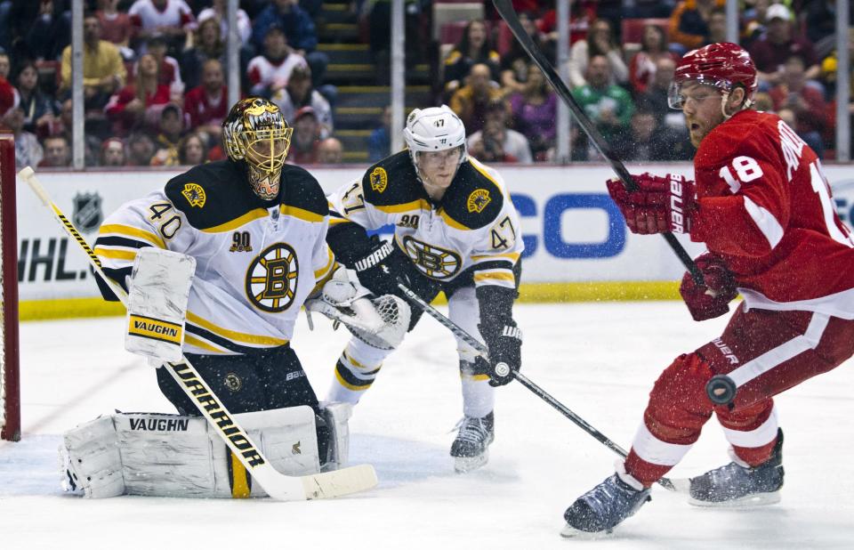 Boston Bruins goalie Tuukka Rask (40), of Finland, and defenseman Torey Krug (47) watch the puck deflect off the left leg of Detroit Red Wings forward Joakim Andersson (18) during the second period of an NHL hockey game in Detroit, Mich., Wednesday, April 2, 2014. (AP Photo/Tony Ding)