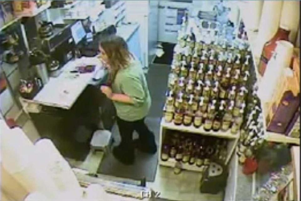 Surveillance video shows Samantha Koenig raising her arms in what looks like a robbery. / Credit: FBI