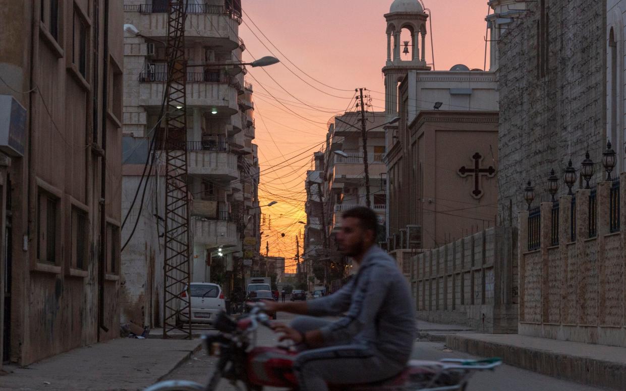 A motorcycle passes by The Virgin Mary church in Qamishli, northern Syria, where Kurdish separatists are facing a fight to hang onto their gains - Sam Tarling