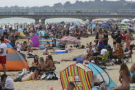 People enjoy the warm weather on Bournemouth beach. Met Office said Friday is the third hottest UK day on record as temperatures reached 37.8C at Heathrow Airport.