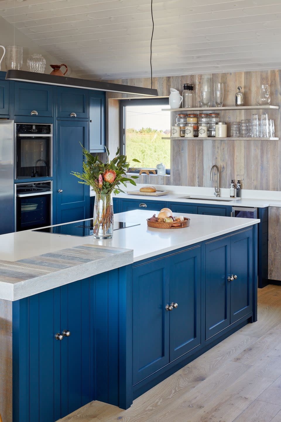 blue kitchen with wooden panelling on walls