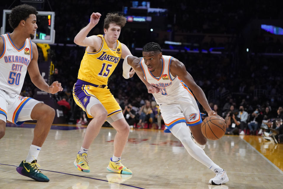 Oklahoma City Thunder guard Shai Gilgeous-Alexander (2) dribbles past Los Angeles Lakers guard Austin Reaves (15) during the second half of an NBA basketball game Thursday, Nov. 4, 2021, in Los Angeles. (AP Photo/Marcio Jose Sanchez)