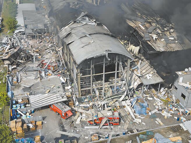 屏東加工出口區高爾夫球代工廠「明揚國際」22日發生爆炸，至23日仍持續悶燒，3部消防車被埋在瓦礫堆中。（黃子明攝）