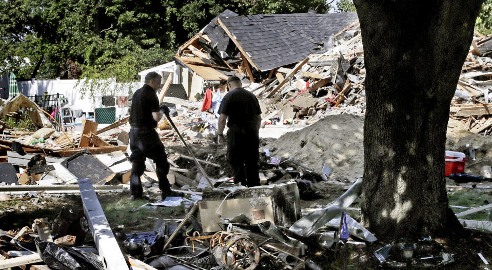 FILE- In this Sept. 21, 2018 file photo, fire investigators pause while searching the debris at a home which exploded following a gas line failure in Lawrence, Mass. Federal investigators are confirming that over pressurized natural gas lines were the source of a series of explosions and fires in communities north of Boston last month. The preliminary report on Thursday, Oct. 11 from the National Transportation Safety Board said that Columbia Gas work in Lawrence on Sept. 13 failed to account for the location of critical gas pressure sensors, causing high-pressure gas to flood the distribution system at excessive levels. (AP Photo/Charles Krupa, File)